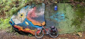 A bicycle leaning against a colourful wall on the Camino trail